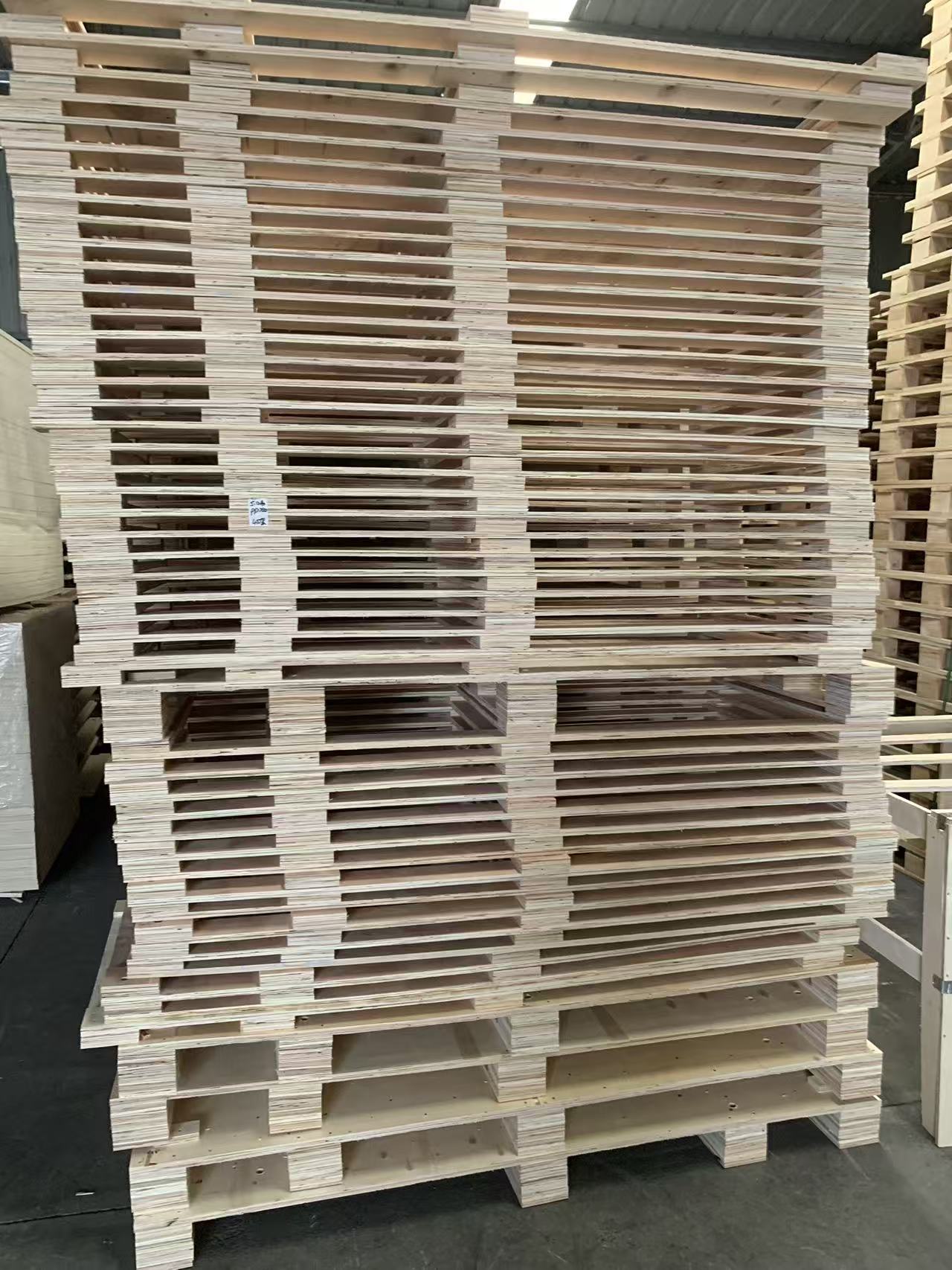 Stacked plywood pallets in factory storage area - engineered wood pallets for cost-effective packaging